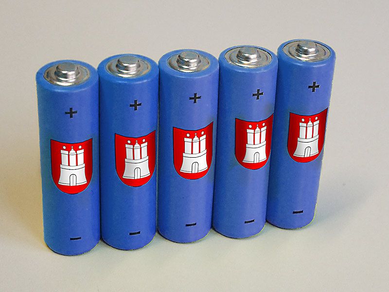 Fünf kleine blaue Batterien mit Hamburg-Symbol auf Schreibtisch