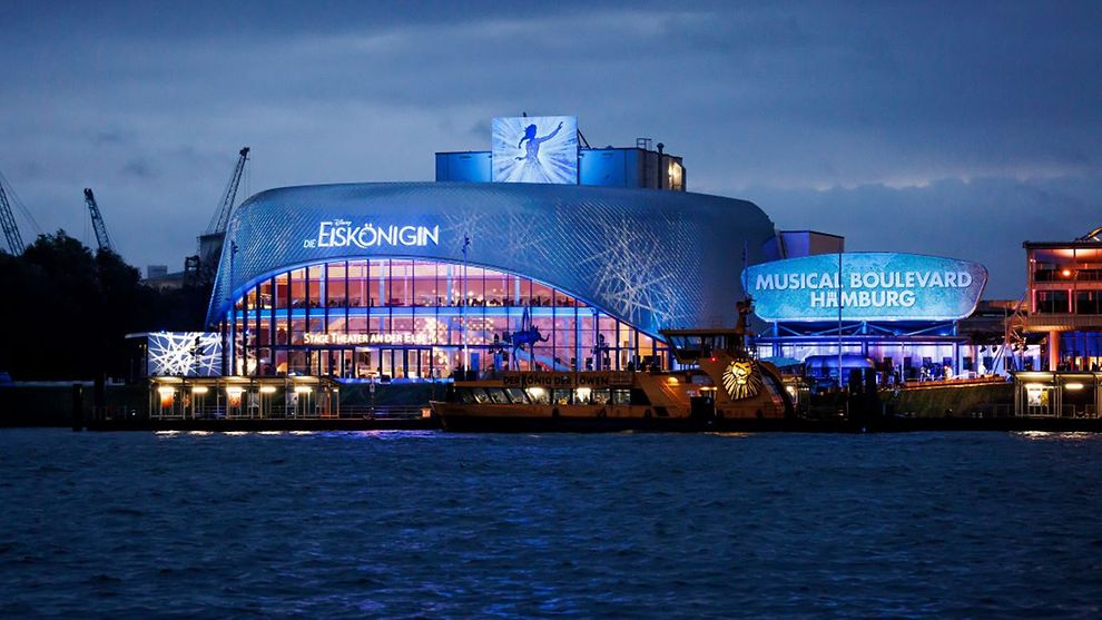 Außenaufnahme des Stage Theaters an der Elbe mit Werbung für Disneys DIE EISKÖNIGIN.