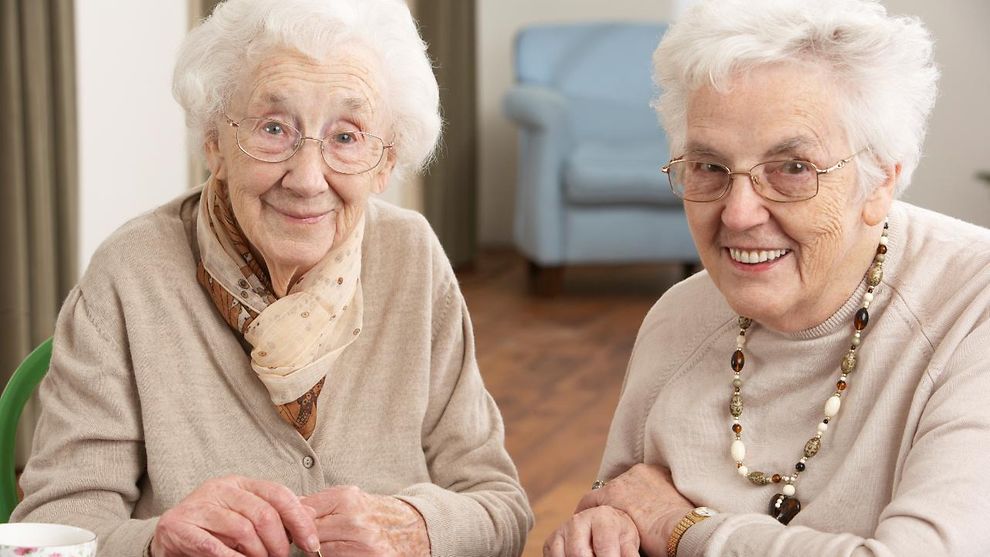 Zwei Seniorinnen spielen ein Gesellschaftsspiel