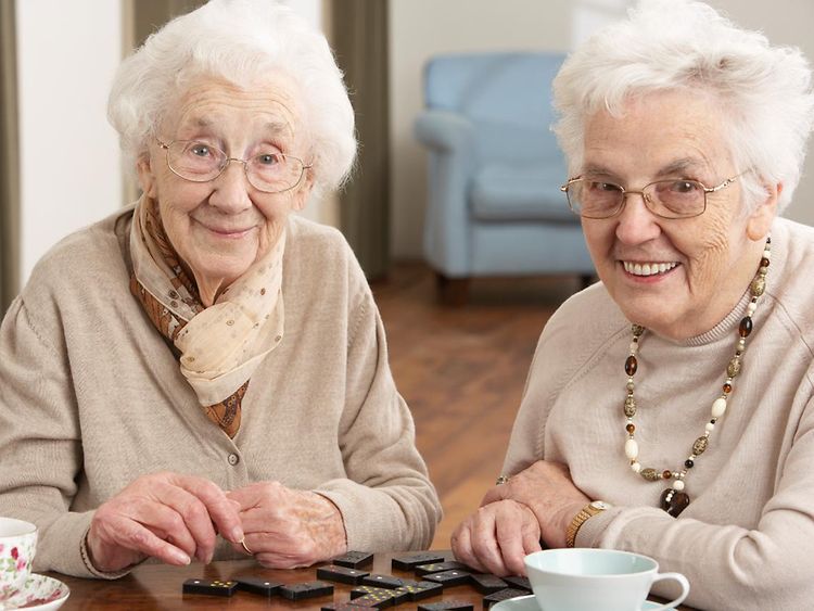  Zwei Seniorinnen spielen ein Gesellschaftsspiel