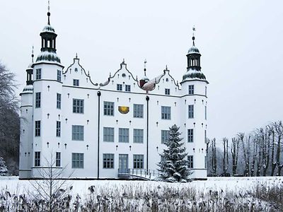 Um das weiße Schloss mit Türmchen in Ahrensburg liegt Schnee.