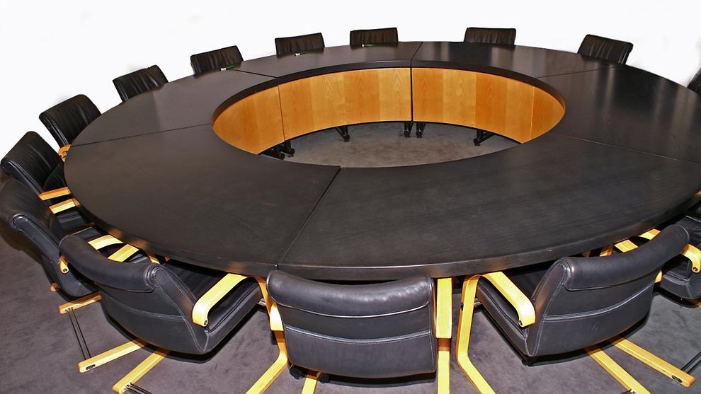 Stühle stehen um einen runden Tisch herum