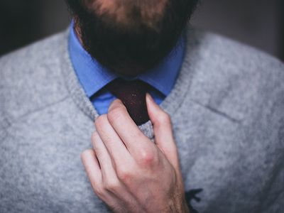  Ein Mann mit Krawatte zeigt seine Hände