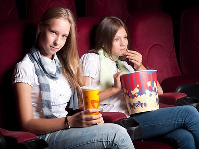  Zwei Mädchen sitzen im Kinosaal