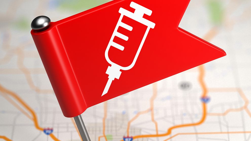Stecknadel mit Impfsybol auf einem Stadtplan gepinnt