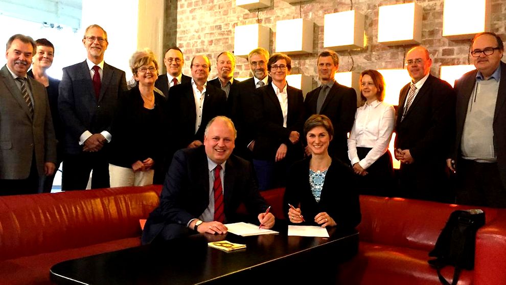 Staatsrat Jan Pörksen (links) und Kerrin Stumpf, Vorstandsmitglied in der LAG für behinderte Menschen, unterzeichnen die Vereinbarung