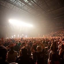  Konzertsaal mit Bühne, Band und feiernden Konzertbesuchern
