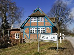  Stadtteilschild von Moorfleet vor einem alten Fachwerkhaus