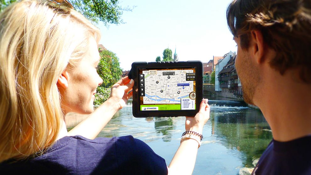  Ein Mann und eine Frau mit einem iPad bei einer Stadtrallye