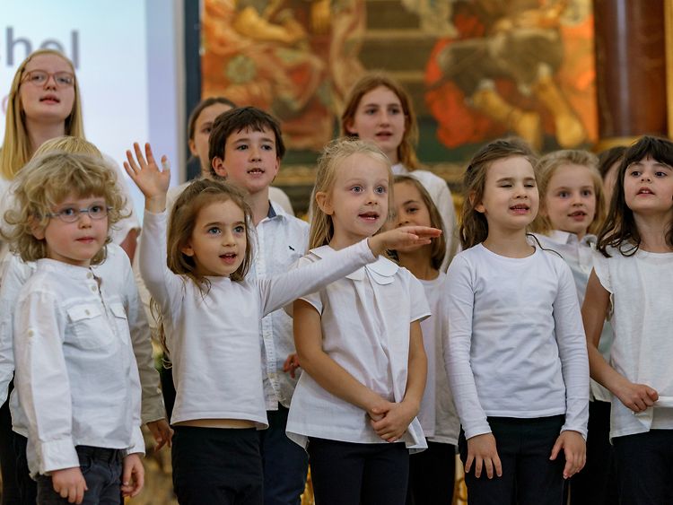  Kinder singen in weißen T-Shirts gekleidet Chorlieder