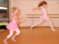  Mädchen in rosa Ballettkleidchen üben Ballettsprünge 