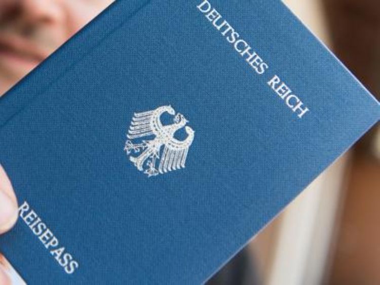  Ein Heft mit dem Aufdruck "Deutsches Reich Reisepass" in der Hand. Foto: Patrick Seeger/Archiv