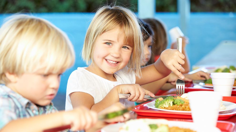 Mehrere kleine Kinder essen zu Mittag