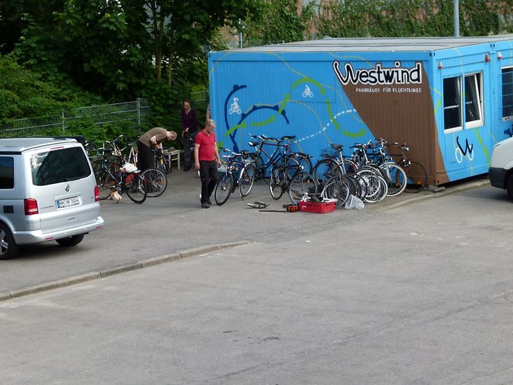  Ein blauer Container, vor dem einige Fahrräder stehen. Der Container ist die Fahrradwerkstatt von Westwind e.V.