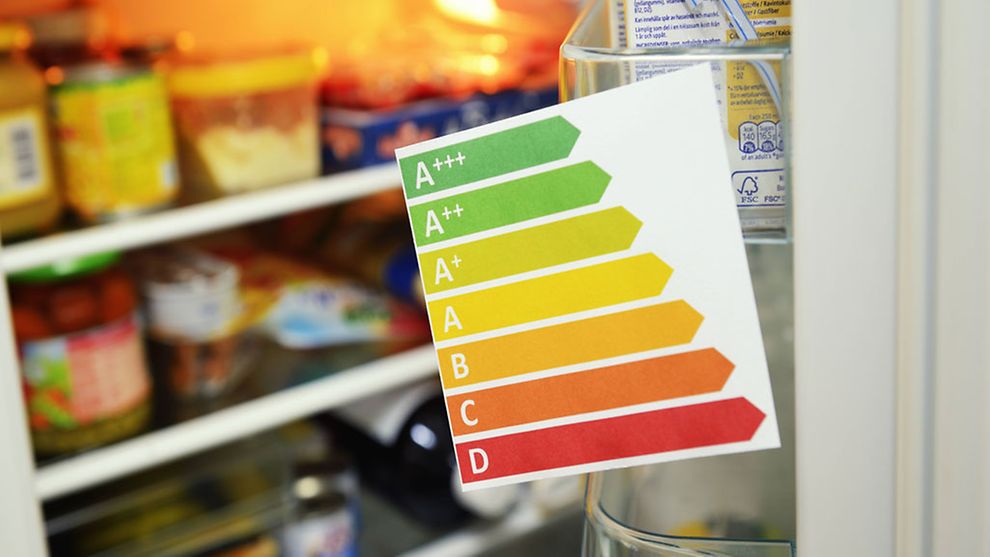  geöffneter Kühlschrank und im Vordergrund eine Energielabel-Liste