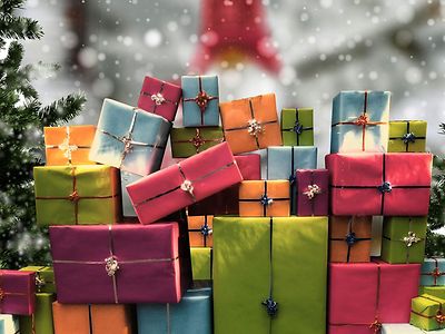  Bunte Geschenkpakete neben einem Weihnachtsbaum